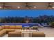 Cozy outdoor seating area with a fire pit overlooking the pool, spa, and lush landscaping at 2610 Eldora Estates Ct, Las Vegas, NV 89117
