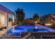 Backyard pool and spa featuring ambient lighting, lush landscaping, and lounge chairs at 2610 Eldora Estates Ct, Las Vegas, NV 89117