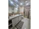 Well-lit bathroom with a granite vanity, decorative mirror, tiled floors, and a glass-enclosed shower at 2913 Domino Way, Las Vegas, NV 89117