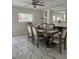 Bright dining room with marble floors and a large window, featuring a wooden dining table and six cushioned chairs at 2913 Domino Way, Las Vegas, NV 89117