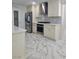 Close-up of modern kitchen featuring white cabinets, stainless steel appliances, and marble tile flooring at 2913 Domino Way, Las Vegas, NV 89117