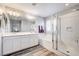 Bright bathroom featuring double sinks, a bathtub with subway tile surround, and a glass-enclosed shower at 3002 Coveri Ct, Las Vegas, NV 89141