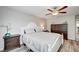 Cozy bedroom with ceiling fan, wood-look floors, and matching dark wood nightstand and dresser at 3002 Coveri Ct, Las Vegas, NV 89141