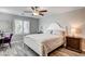 Cozy bedroom featuring a queen-size bed, shuttered window, ceiling fan, and wood-look floors at 3002 Coveri Ct, Las Vegas, NV 89141