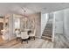 Cozy dining area featuring a crystal chandelier, elegant mirror, and access to a staircase at 3002 Coveri Ct, Las Vegas, NV 89141