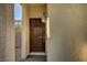 Close-up of a dark brown front door with a decorative lantern and neutral stucco exterior at 3002 Coveri Ct, Las Vegas, NV 89141