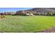 Expansive green lawn with landscaping, offering scenic views of surrounding homes and hills at 3002 Coveri Ct, Las Vegas, NV 89141