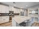 Modern kitchen boasts stainless appliances, granite countertops, island with seating, and ample cabinet space at 3002 Coveri Ct, Las Vegas, NV 89141