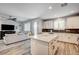 Open kitchen concept flowing into the living room, featuring granite island and modern appliances at 3002 Coveri Ct, Las Vegas, NV 89141