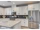 Modern kitchen boasts stainless appliances, granite countertops, island with seating, and ample cabinet space at 3002 Coveri Ct, Las Vegas, NV 89141