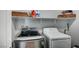 Laundry area equipped with front load washer, dryer, and upper shelving at 3002 Coveri Ct, Las Vegas, NV 89141