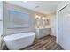 Bright bathroom features soaking tub, double sinks, and wood-look floors at 3016 Mount Charleston Dr, Pahrump, NV 89048