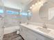 Bright bathroom with double sinks, marble countertops, a tiled shower, and modern lighting fixtures at 3016 Mount Charleston Dr, Pahrump, NV 89048
