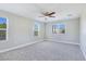 Bright, spacious bedroom featuring plush carpet, a ceiling fan, and multiple windows with horizontal blinds at 3016 Mount Charleston Dr, Pahrump, NV 89048