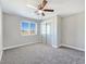 Spacious bedroom featuring plush carpet, a ceiling fan, a window with blinds, and a sliding door closet at 3016 Mount Charleston Dr, Pahrump, NV 89048