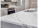 Close up of a modern kitchen island with a marble countertop and stainless steel sink and faucet at 3016 Mount Charleston Dr, Pahrump, NV 89048