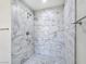 Elegant shower featuring marble-patterned tile surround and mosaic tile floor at 3016 Mount Charleston Dr, Pahrump, NV 89048