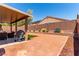 Backyard featuring a covered patio area with seating, a grill and desert landscaping at 312 Purple Passion Ave, North Las Vegas, NV 89032