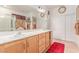 Bright bathroom with double sinks, quartz counters, and ample storage in wood cabinets at 312 Purple Passion Ave, North Las Vegas, NV 89032