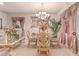 Formal dining area with a glass table, decorative chairs, and stylish window treatments at 312 Purple Passion Ave, North Las Vegas, NV 89032