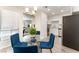 Open dining area with a glass table, blue chairs, and a view into the living room and kitchen at 3151 Soaring Gulls Dr # 1021, Las Vegas, NV 89128