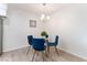 Cozy dining area with a glass table, four blue chairs, and contemporary lighting at 3151 Soaring Gulls Dr # 1021, Las Vegas, NV 89128
