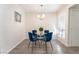 Dining room featuring a round glass table, four blue chairs, and a modern light fixture above at 3151 Soaring Gulls Dr # 1021, Las Vegas, NV 89128