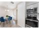 Dining area adjacent to a modern kitchen with stainless steel appliances and white cabinetry at 3151 Soaring Gulls Dr # 1021, Las Vegas, NV 89128