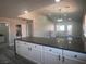 Bright, open kitchen with white cabinets, dark countertops and updated lighting fixture at 3327 Erva St # 222, Las Vegas, NV 89117