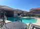 Community pool with black metal furniture and nearby condos on a sunny day at 3327 Erva St # 222, Las Vegas, NV 89117