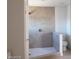 Updated bathroom with a tiled shower, gray accent tile, shower head, and toilet at 3439 Cox St, North Las Vegas, NV 89032