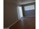 Bedroom with hardwood floors, neutral walls, sliding glass doors, and white curtains at 3439 Cox St, North Las Vegas, NV 89032