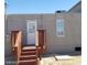 Back exterior with a wooden deck and stairs leading to a door, with a window nearby at 3439 Cox St, North Las Vegas, NV 89032