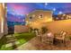 Cozy backyard with lush turf, brick-paved patio, string lights and a stone fire pit, perfect for relaxation at 360 Rosefinch St, Henderson, NV 89012
