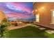 Beautiful backyard with city views, a fire pit, brick-paved patio, artificial turf, and string lights at 360 Rosefinch St, Henderson, NV 89012
