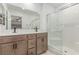 Modern bathroom boasts double sinks, a large mirror, wood cabinets, and a glass-enclosed shower with tile surround at 360 Rosefinch St, Henderson, NV 89012