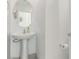 Half bathroom with a pedestal sink and a round mirror at 360 Rosefinch St, Henderson, NV 89012
