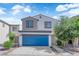 Charming two-story home featuring a bright blue garage door, landscaped front yard, and neutral exterior paint at 3677 Via El Monte Ave, Las Vegas, NV 89115