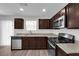 Modern kitchen boasts stainless steel appliances, granite countertops, dark cabinets, and abundant natural light at 3677 Via El Monte Ave, Las Vegas, NV 89115