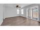 Spacious living room featuring sleek vinyl flooring, contemporary ceiling fan, and sliding door access to the outdoors at 3677 Via El Monte Ave, Las Vegas, NV 89115
