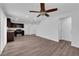 Open floor plan features modern kitchen with stainless appliances, spacious living area with ceiling fan, and vinyl floors at 3677 Via El Monte Ave, Las Vegas, NV 89115