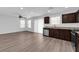 Open-concept kitchen and living area with stainless steel appliances, granite countertops, and modern vinyl flooring at 3677 Via El Monte Ave, Las Vegas, NV 89115