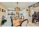 Open dining area with a modern chandelier, a wooden table with seating for six, and access to the kitchen at 4217 Bridesmaid Falls Ave, North Las Vegas, NV 89085