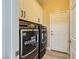 Modern laundry room featuring a full-size washer and dryer with built-in cabinets at 4217 Bridesmaid Falls Ave, North Las Vegas, NV 89085