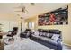 Comfortable living room with a leather sofa, ceiling fan, and a large art piece at 4217 Bridesmaid Falls Ave, North Las Vegas, NV 89085