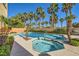 A stunning backyard pool and spa surrounded by lush palm trees and landscaping at 4217 Bridesmaid Falls Ave, North Las Vegas, NV 89085