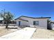 Front exterior view of house, showcasing walkway, blue door and black trim at 4324 El Conlon Ave, Las Vegas, NV 89102