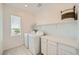 Well-lit laundry room includes appliances, a white countertop, and cabinetry for organizing laundry supplies at 4364 Contour Bend Ave, North Las Vegas, NV 89084