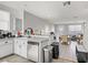 Open kitchen featuring tile floors, white cabinetry, modern appliances, and an adjoining dining area at 5324 Pendergrass St, North Las Vegas, NV 89081