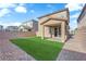 A well-manicured backyard featuring artificial turf and a covered patio, perfect for outdoor enjoyment at 5677 Asyma Ct, Las Vegas, NV 89113